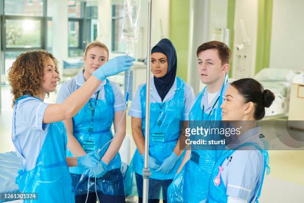 medical student iv training - apron gloves stock pictures, royalty-free photos & images