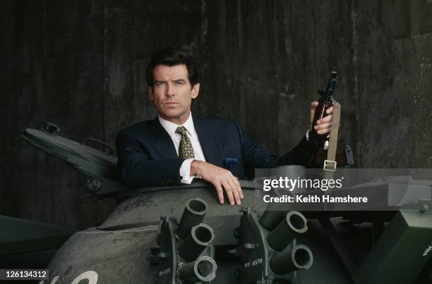 Irish actor Pierce Brosnan poses in the hatch of a Russian T55 Main Battle Tank holding a Kalashnikov automatic rifle, in a publicity still for the...