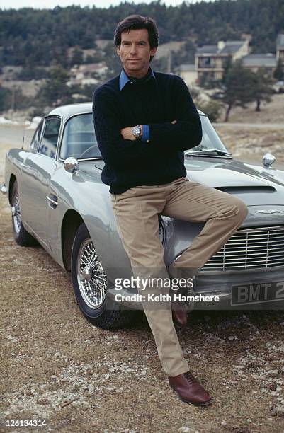Irish actor Pierce Brosnan poses against an Aston Martin DB5 in a publicity still for the James Bond film 'GoldenEye', 1995.