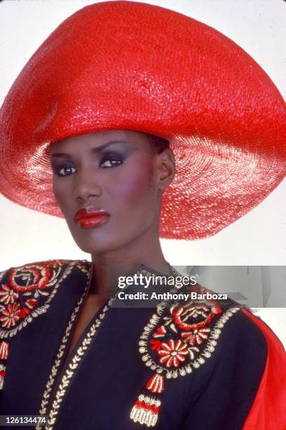 Portrait of Jamaican-born model, singer, and actress Grace Jones, wearing a bright red hat and multi-colored top, New York, late twentieth century.