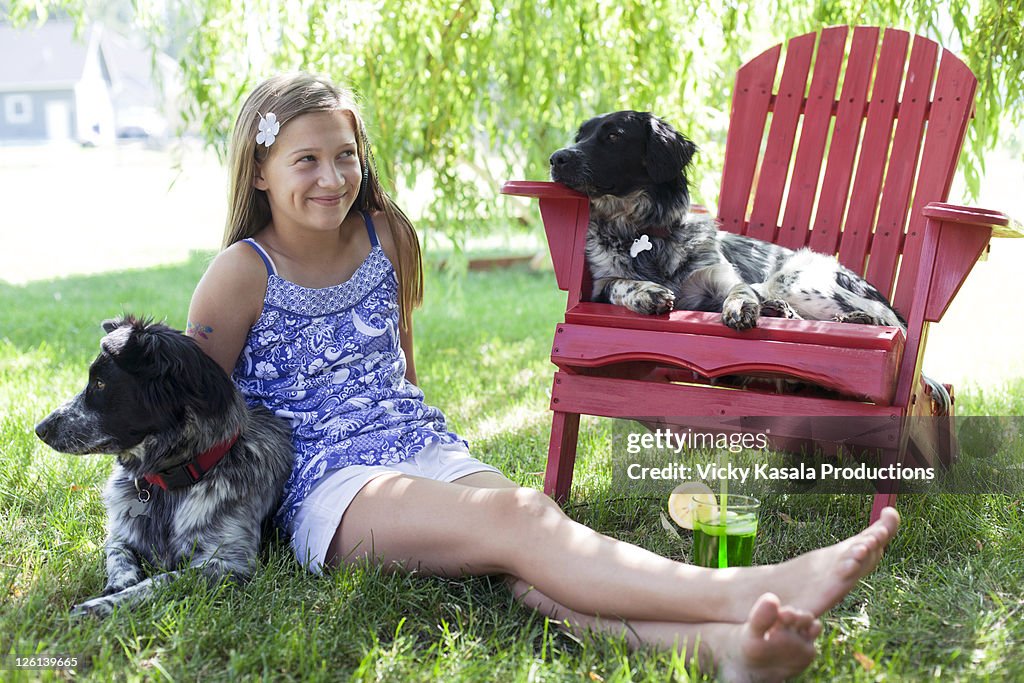 Teen girl w/ her two adopted dogs sitting in shade