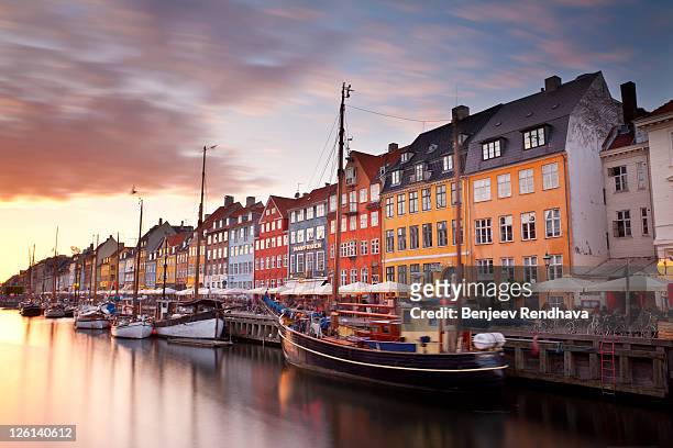 sunset on nyhavn canal, copenhagen, denmark. - copenhagen foto e immagini stock