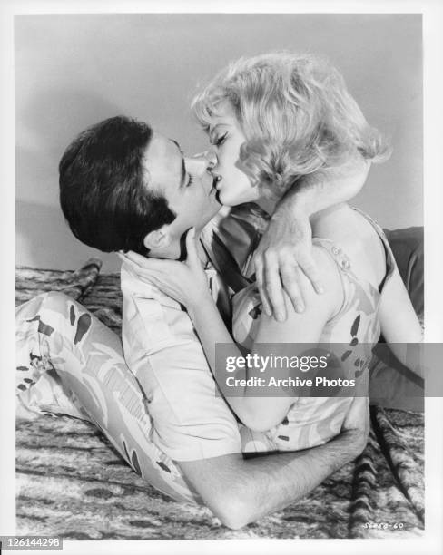 Gene Kirkwood and Mimsy Farmer passionately kissing in a scene from the film 'Hot Rods To Hell', 1966.