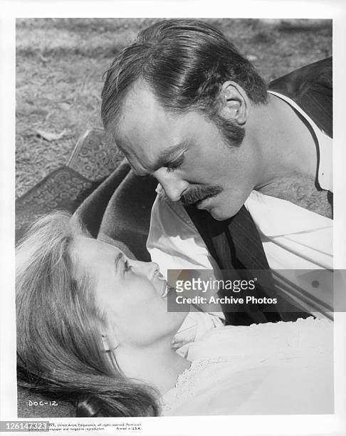 Stacy Keach and Faye Dunaway romantically picnic by a stream in a scene from the film 'DOC', 1971.