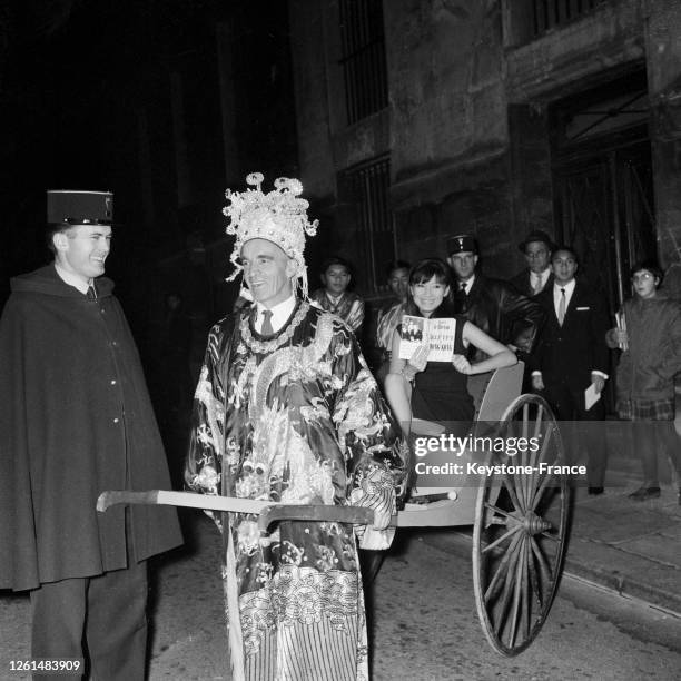 écrivain Auguste Le Breton, habillé d'un costume chinois, tire la jeune chanteuse Tiny Yong confortablement installée dans un pousse-pousse, à Paris,...