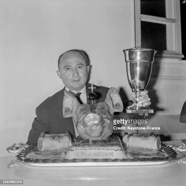 Marc Coulon devant le plat de sa fabrication, une tête de sanglier, soulève la coupe, à Paris, France le 27 octobre 1964.