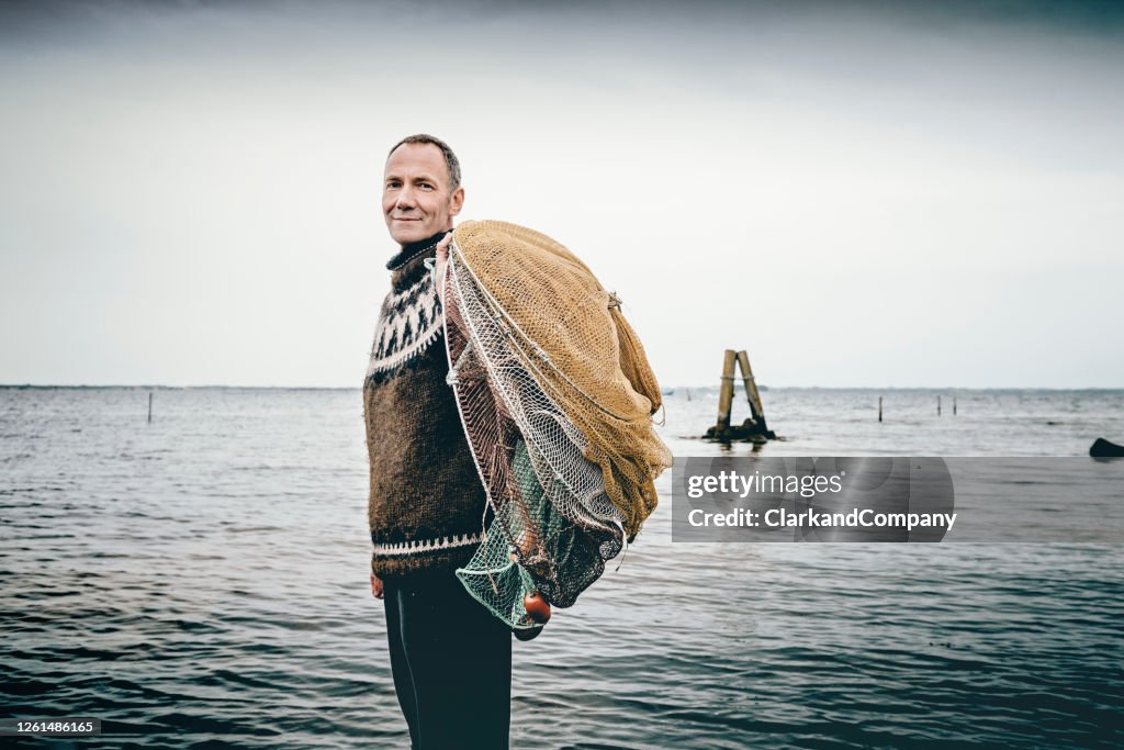 Shrimp fisherman setting out his nets in the sea.