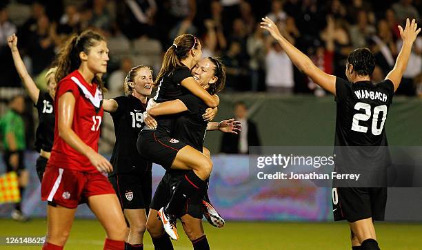 Alex Morgan of the United States is hoisted by Lauren Cheney after scoing a goal againstof Canada on September 22, 2011 at Jeld-Wen Field in...