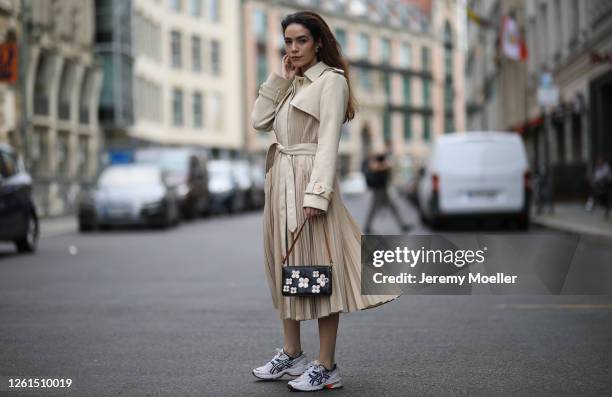 Frankie Miles wearing Sandro trenchcoat, dad sneakers ASICS gel 1090 and mini pouch Louis Vuitton on July 27, 2020 in Berlin, Germany.