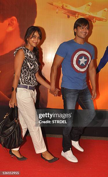 Indian Bollywood actor Vivek Oberoi walks with his wife Priyanka as they attend the premiere for the Hindi film " Mausam" in Mumbai late September...