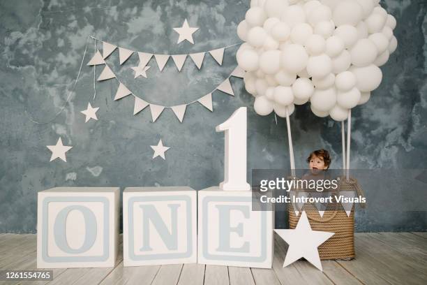 cute baby boy celebrating first birthday in beautiful light blue decorations - 1st birthday stock pictures, royalty-free photos & images