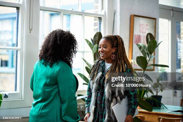 two women talking in creative office - people say hello stock pictures, royalty-free photos & images