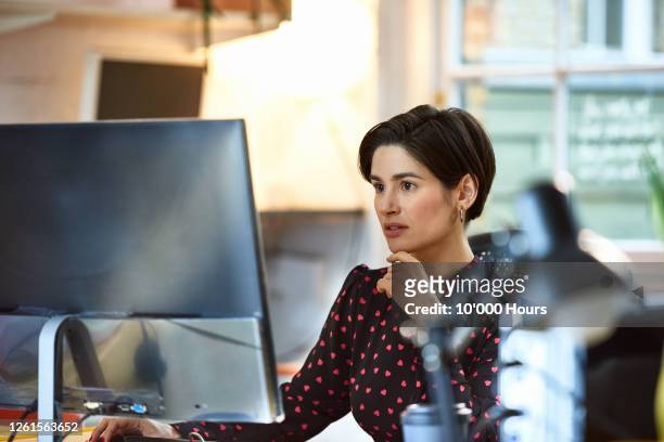 mediterranean woman using computer in office - computer stock pictures, royalty-free photos & images