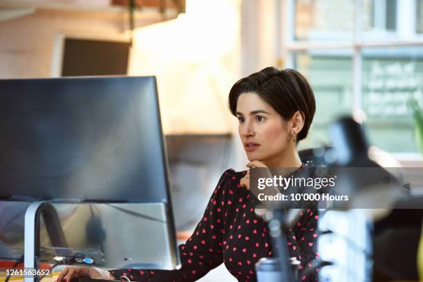 mediterranean woman using computer in office - using computer office stock pictures, royalty-free photos & images