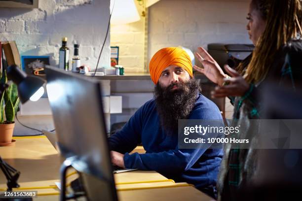 sikh man listening to advice from female colleague - sikhism stock pictures, royalty-free photos & images