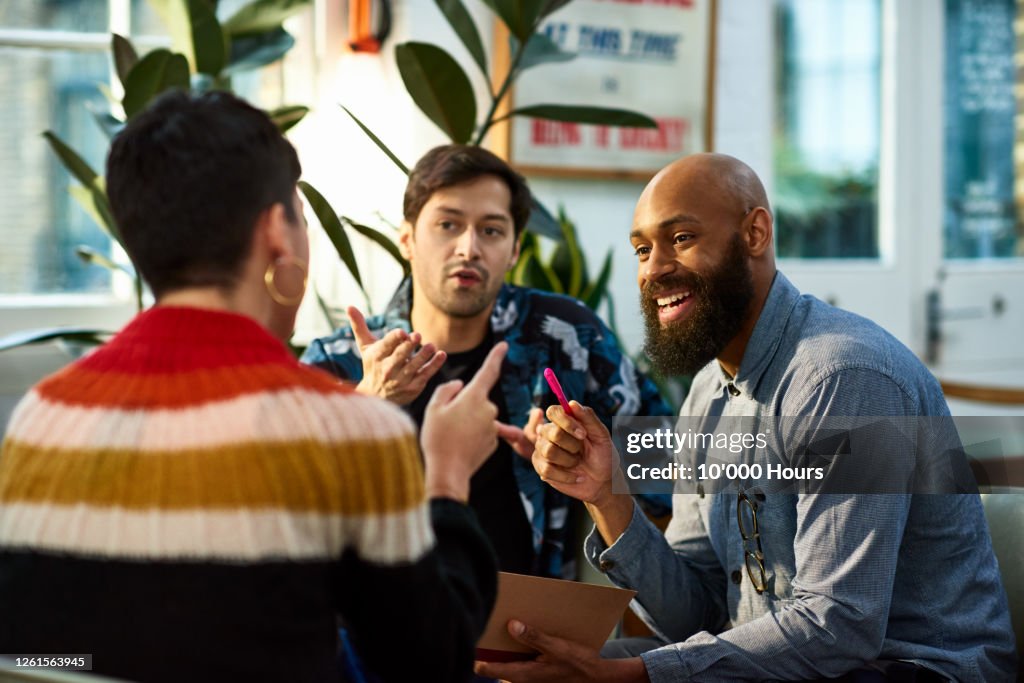 Multi ethnic group sharing ideas in office