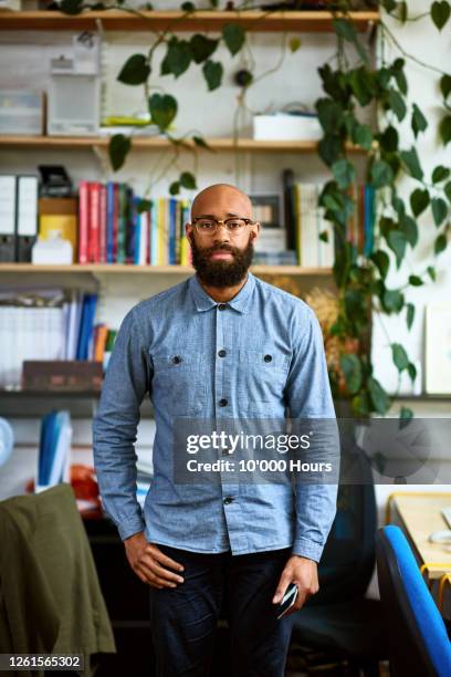 black entrepreneur in office looking at camera - black business owner ストックフォトと画像