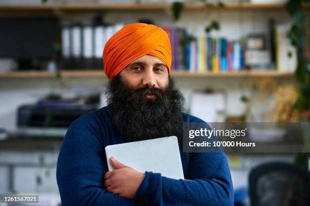sikh man holding laptop, looking at camera - doutrina dos siques - fotografias e filmes do acervo