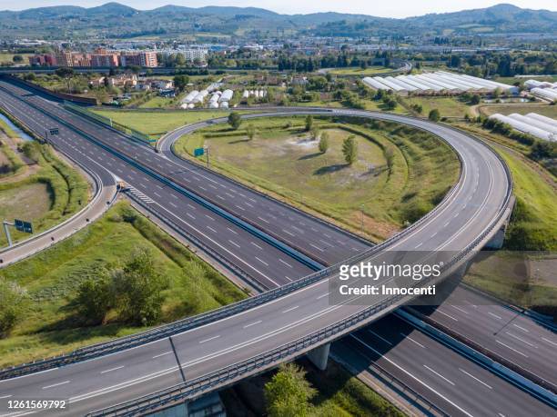 aerial view of empty motorway junction in florence, italy during the corona virus crisis. - autostrada foto e immagini stock