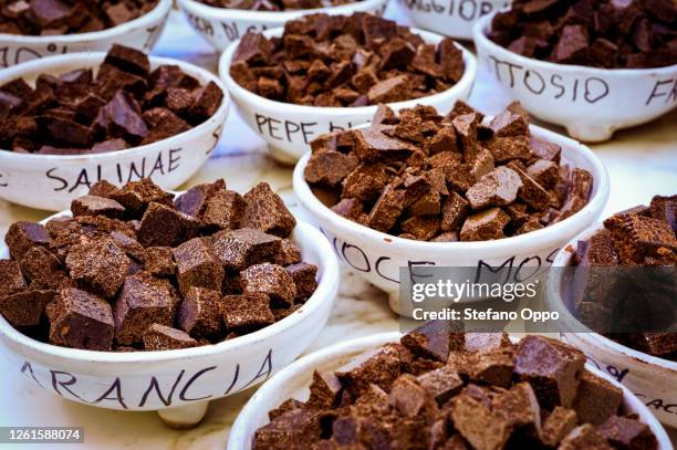 high angle close up of different types of chocolates in white ceramic bowls with black handwriting in modica, sicily, italy. - modica stock-fotos und bilder