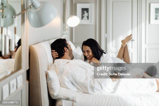 couple laughing and relaxing in suite - hotel de lujo fotografías e imágenes de stock