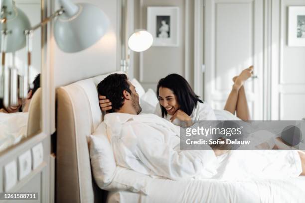 couple laughing and relaxing in suite - couple hotel stock pictures, royalty-free photos & images
