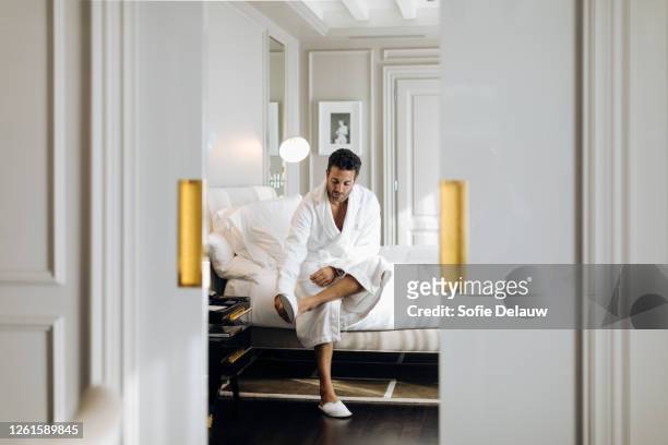 man wearing bedroom slipper in suite - cama lujo fotografías e imágenes de stock