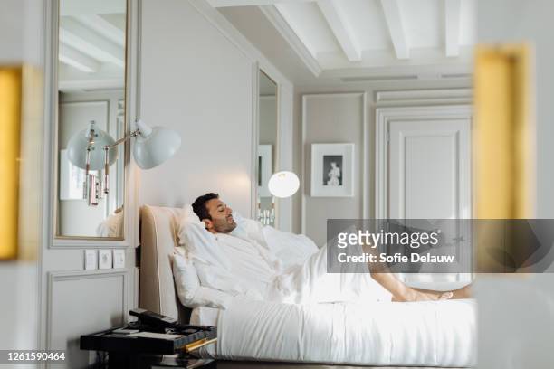 man relaxing in suite - bedroom suite stock-fotos und bilder