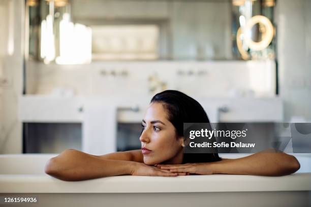 woman relaxing in bathtub in suite - bad thoughts stockfoto's en -beelden