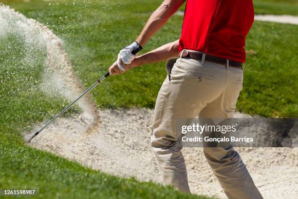 male golfer chipping out of sand trap. - golfhandschuh stock-fotos und bilder