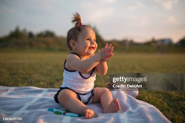 smiling baby girl playing with soap bubbles in park - hot babe stock pictures, royalty-free photos & images