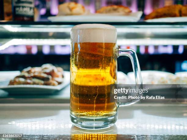 pint of beer on the bar counter - pinchos stock-fotos und bilder