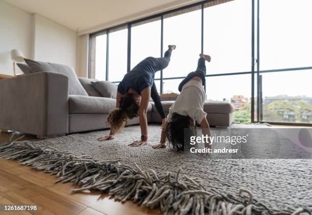 mère enseignant à son fils comment faire un handstand à la maison - yoga rug photos et images de collection