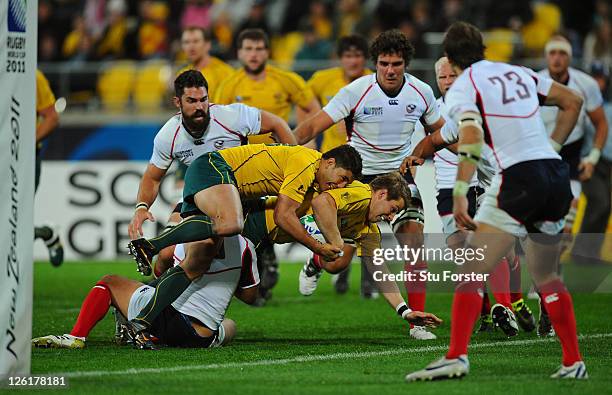 Drew Mitchell of the Wallabies is driven over the line by teammate Anthony Fainga'a to score his team's fifth try during match 23 of the IRB 2011...