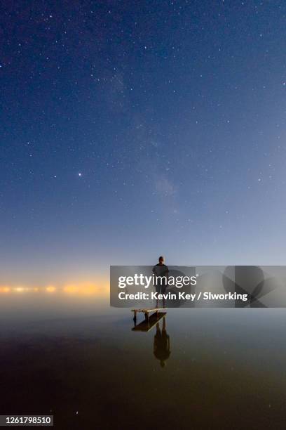 man standing on diving board in lake at night - installation art stock pictures, royalty-free photos & images