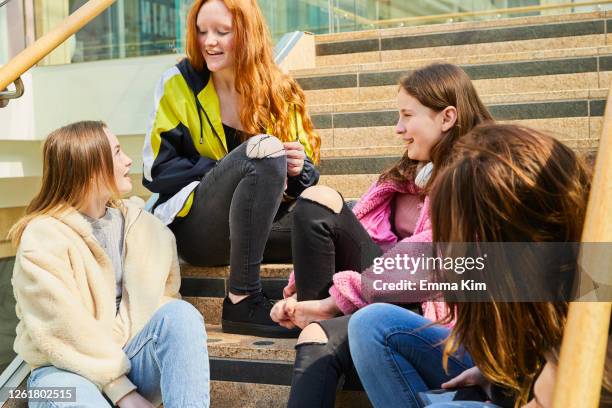 group of teenage girls sitting on staircase in a shopping mall, chatting. - guildford bildbanksfoton och bilder