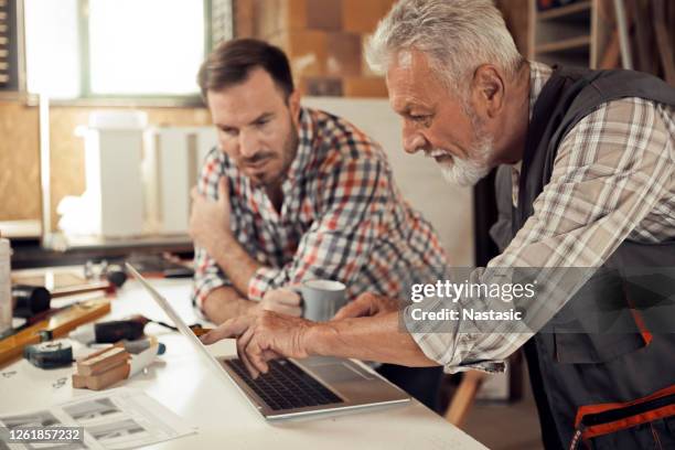father and son carpenters working together - business relations stock pictures, royalty-free photos & images
