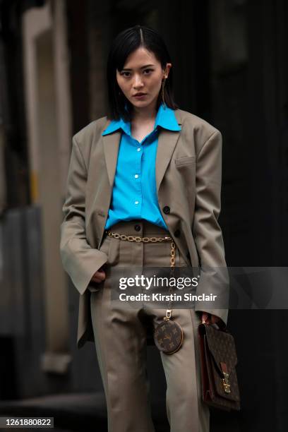 Digital influencer Freya Sinyu Siu wears Louis Vuitton bags, Delada suit, Jenn Lee earrings and Mikio Sakabe shirt during London Fashion Week...