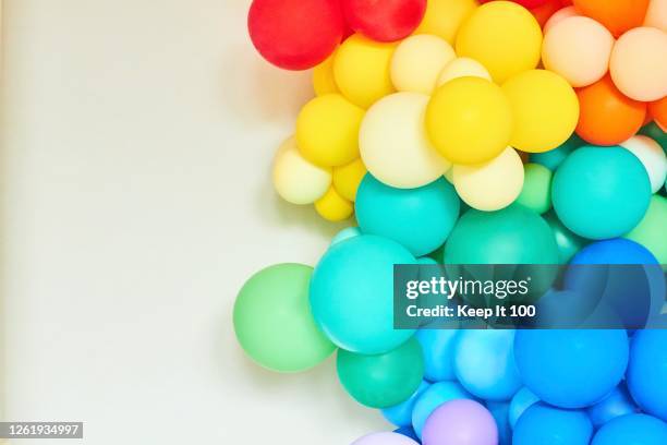 a rainbow coloured collection of balloons - party decoration stock pictures, royalty-free photos & images