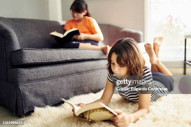 dos niñas en una sala de estar leyendo libros - sala de estar stock pictures, royalty-free photos & images