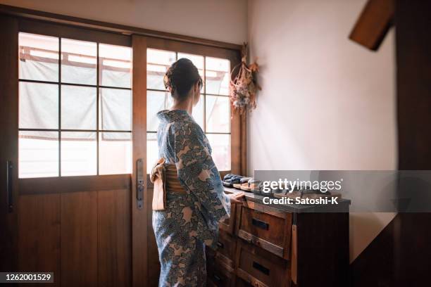 japanese woman in yukata standing at japanese ‘ryokan’ hotel entrance - yukata stock pictures, royalty-free photos & images