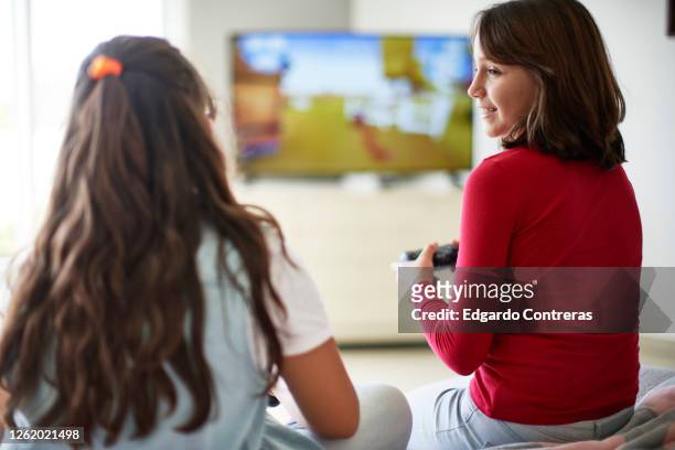 dos niñas frente a un televisor jugando videojuegos - televisore stock pictures, royalty-free photos & images