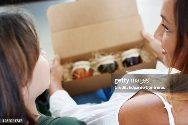 madre e hija con caja de cartón - cartón stock-fotos und bilder