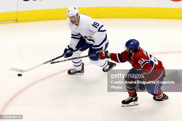 Jason Spezza of the Toronto Maple Leafs takes the puck as Xavier Ouellet of the Montreal Canadiens defends in the second period during an exhibition...