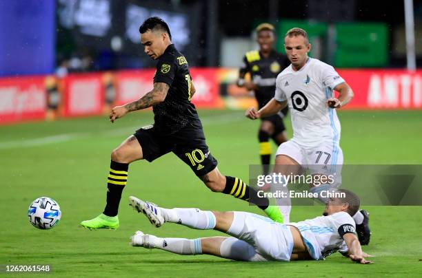 Osvaldo Alonso of Minnesota United slides to protect the ball from Lucas Zelarrayan of Columbus Crew in the first half during a round of sixteen...