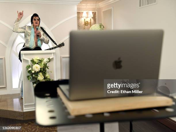 Elvis Presley impersonator and chapel co-owner Brendan Paul performs a live wedding vow renewal ceremony using the Zoom videoconferencing software...