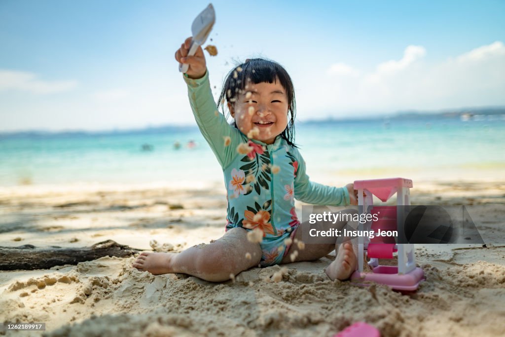 Baby girl playing on beach