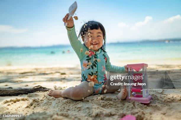 baby girl playing on beach - kota kinabalu beach stock pictures, royalty-free photos & images