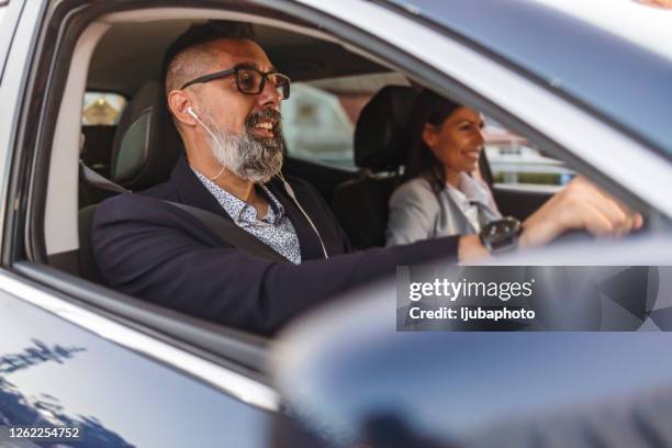 business couple having a conversation while driving a car in the city - music from the motor city stock pictures, royalty-free photos & images