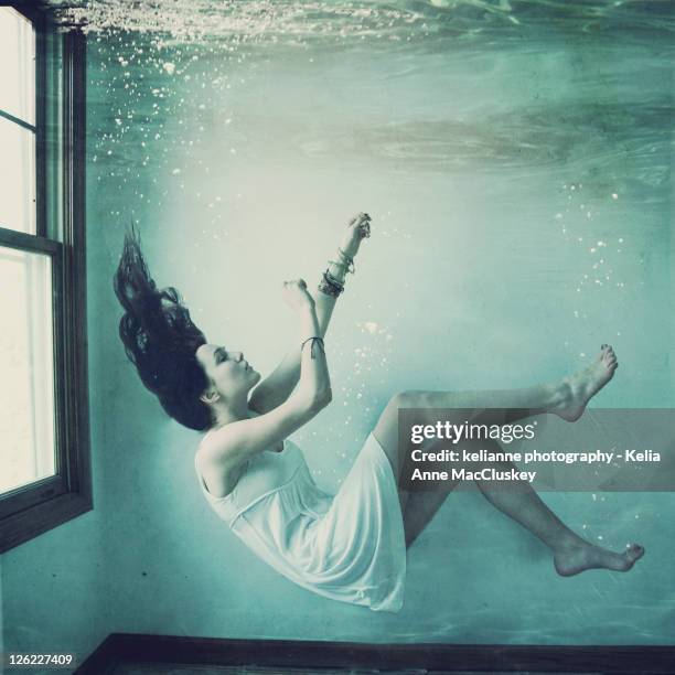 girl floating underwater in house - underwater room stock pictures, royalty-free photos & images